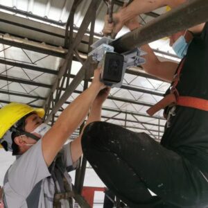 Energy-saving industrial ceiling fan installation team at work